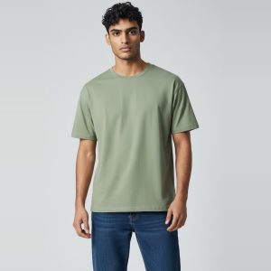 Model wearing sage green plain t-shirt, colour code #A3B18A – Bulk Cloth Store